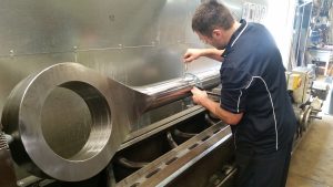 a person inspecting a hydraulic cylinder